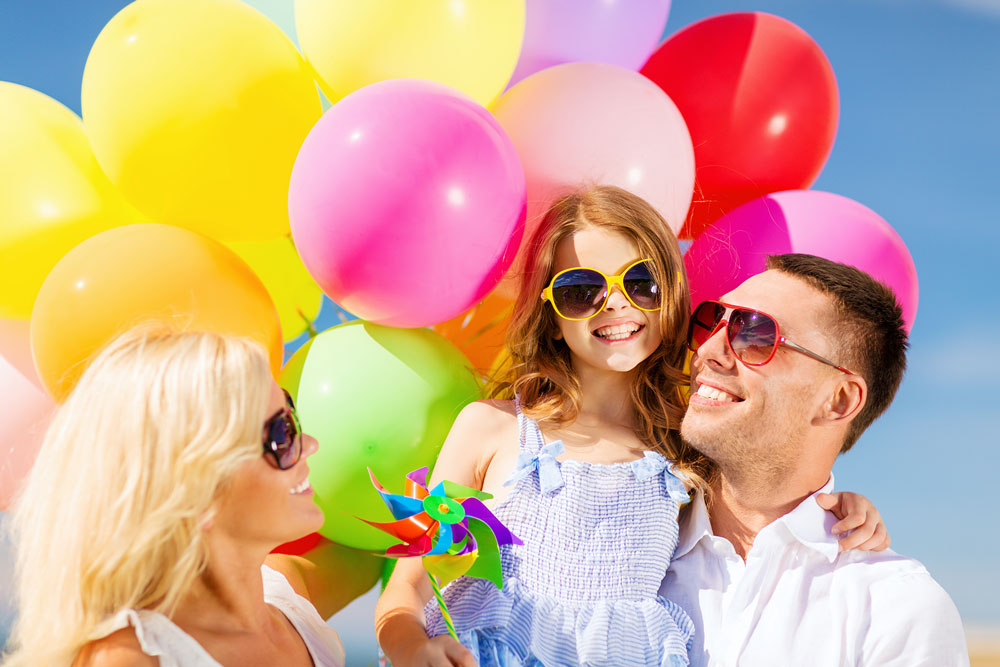Parents & Daughter in front of Colorful Balloons